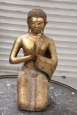 a gold statue of a person sitting on a table