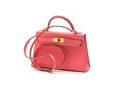 the small pink bag is on a white surface