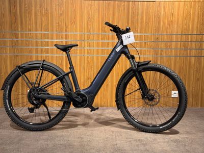 un vélo électrique noir garé devant un mur en bois