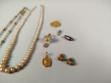 many different types of necklaces and earrings on the table