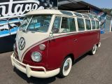 un minibus Volkswagen rouge et blanc garé devant un immeuble