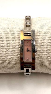 someone is wearing a watch on their wrist on a white cloth