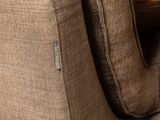 the back of a brown couch with a wooden table in the background