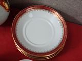 a white plate with gold trim and a red table cloth