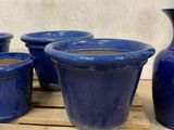 four blue pots sitting on a pallet next to each other