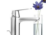 a vase with a flower in it next to a faucet
