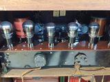 une étagère en bois sur laquelle sont posés tout un tas d'appareils électroniques
