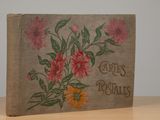 an old book sitting on top of a wooden table covered in flowers