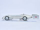 a silver model of a race car on a clear surface