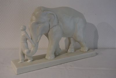 une statue représentant un éléphant et un homme debout l'un à côté de l'autre