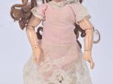 a small doll that is wearing a pink dress