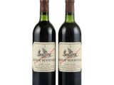 two bottles of red wine sitting next to each other on a white surface