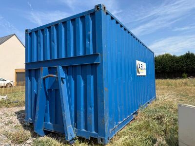 a blue container sitting in the middle of a field