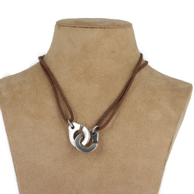 collier en cuir marron avec un pendentif en argent autour du cou d'un mannequin