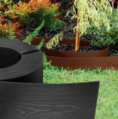 un gros plan sur une jardinière en plastique noir dans un jardin