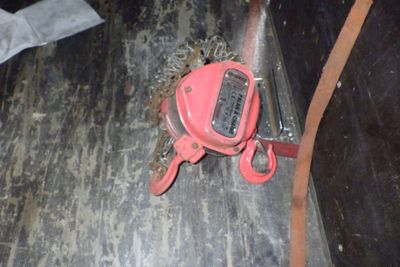 un objet rouge posé par terre à côté d'une paire de ciseaux