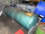a large green tank sitting next to a blue barrel