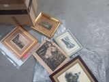 a box of framed pictures on the floor next to a box of framed pictures