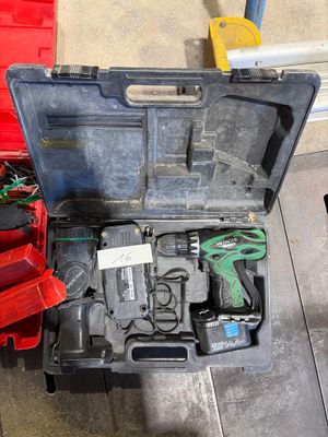 une boîte à outils contenant des outils, posée sur le sol