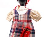 un mannequin coiffé d'un chapeau rouge et vêtu d'une robe à carreaux