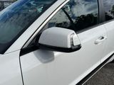 a white car parked in a parking lot with its door open