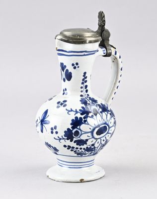 un vase bleu et blanc surmonté d'un oiseau