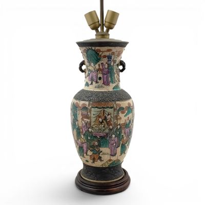 a large vase with a lamp on top of it