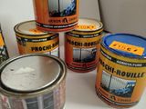 several tins of paint sitting on top of a white counter