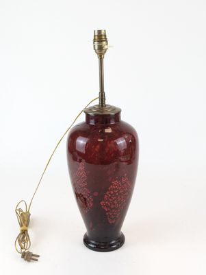 une image représentant un vase rouge surmonté d'une lampe