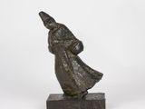 a bronze statue of a man in a robe and hat