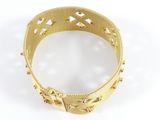 a close up of a gold bracelet on a white surface