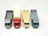 four toy trucks sitting next to each other on a white surface