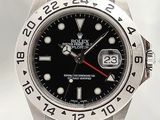 Montre Rolex avec cadran noir et aiguilles rouges, montée sur un bracelet en acier