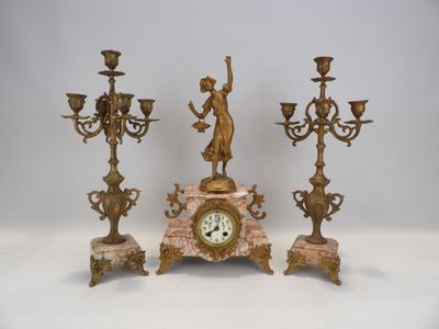 trois bougies et une horloge posées sur une table