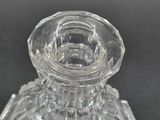 a clear glass candle holder on a black surface