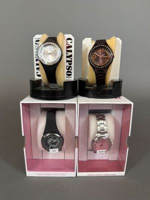 trois montres sont exposées dans une vitrine posée sur une surface grise