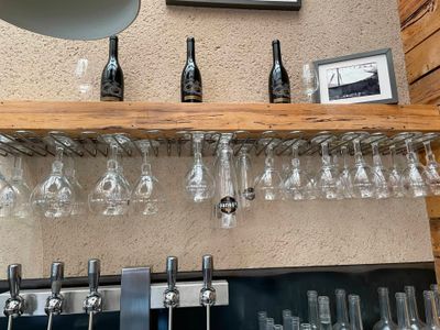 une étagère sur laquelle sont posés des verres à vin et des bouteilles