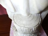 a statue of a woman holding a cup on a table
