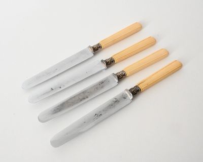 three knives with wooden handles on a white surface