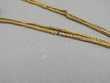 a close up of a gold necklace with a chain attached to it