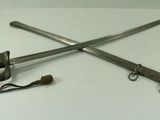 two swords on a white table with a black strap