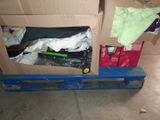 a cardboard box on a pallet with a green toothbrush in it