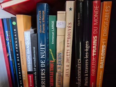 a lot of books that are on a shelf together