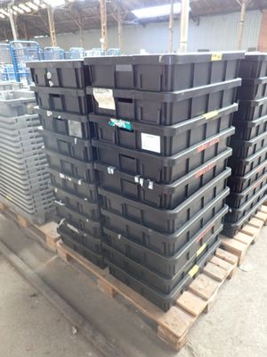 many black boxes stacked on a pallet in a warehouse