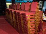 rows of chairs in a room with red carpet and red carpeting