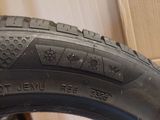 the tire of a motorcycle is sitting on the floor in front of a cardboard box