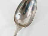 a spoon that is sitting on a white surface