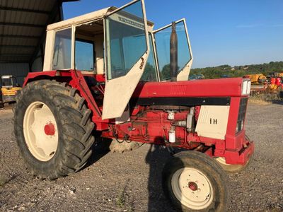 un tracteur rouge garé sur un parking