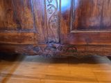 a wooden cabinet with carvings on the top of it