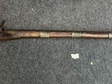 an old gun with a wooden handle on a carpet